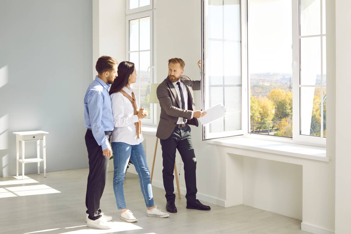 Three people discussing a large set of windows during a consultation at Window Fashions of Northern California near Fairfield and Fremont, CA